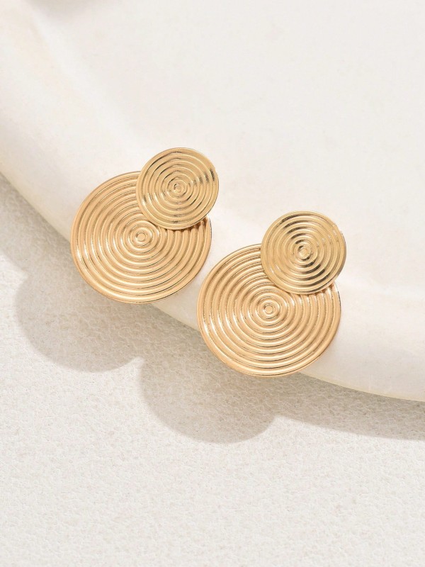 Kolczyki Złote Kręgi Światła – złote kolczyki o spiralnym wzorze, geometryczna biżuteria w stylu nowoczesnej elegancji dla kobiet.
