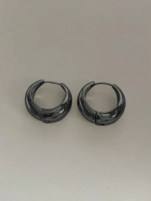 Kolczyki Noir Paris – małe czarne kolczyki koła o lustrzanym połysku, minimalistyczna biżuteria w stylu francuskim.