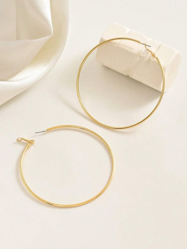 Duże cienkie kolczyki w kształcie okręgów w kolorze złotym noszone na uchu (4).webp