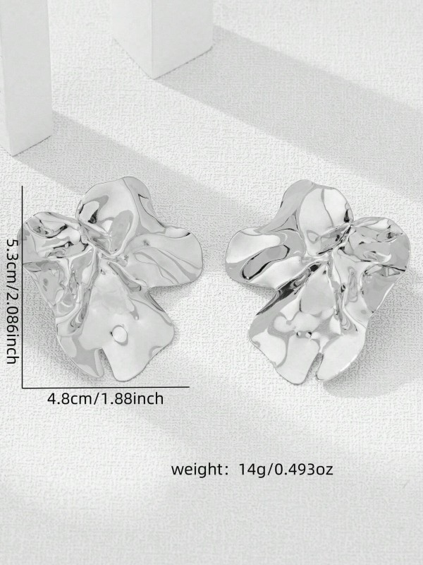 Duże srebrne kolczyki w kształcie nieregularnych, pofalowanych płatków o błyszczącej powierzchni (5).webp