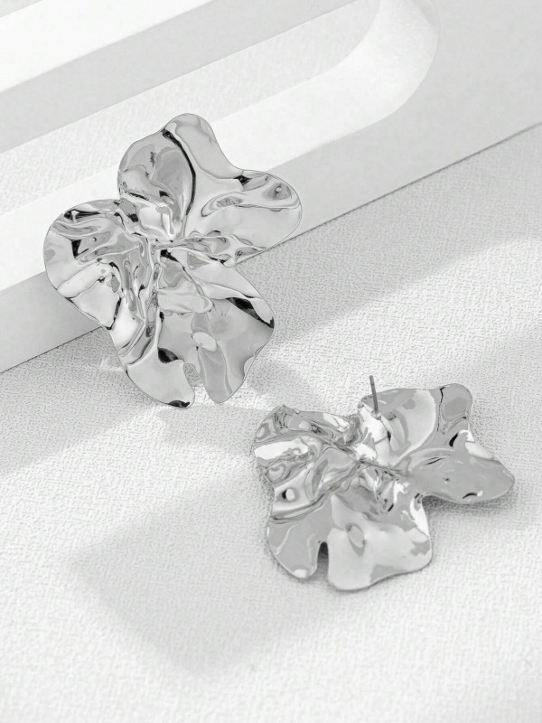 Duże srebrne kolczyki w kształcie nieregularnych, pofalowanych płatków o błyszczącej powierzchni (4).webp