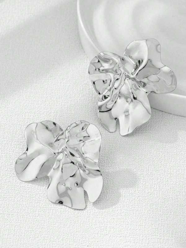 Duże srebrne kolczyki w kształcie nieregularnych, pofalowanych płatków o błyszczącej powierzchni (3).webp