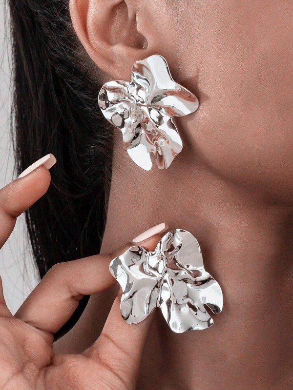 Duże srebrne kolczyki w kształcie nieregularnych, pofalowanych płatków o błyszczącej powierzchni (2).webp