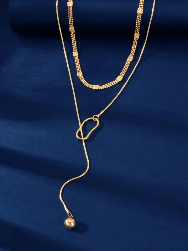 Złoty naszyjnik z podwójnym łańcuszkiem, geometryczną zawieszką i opadającym elementem zakończonym kulką (3).webp