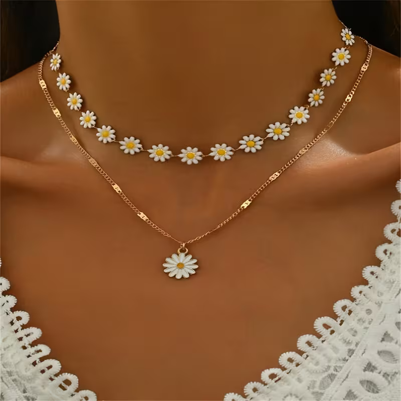 Zestaw dwóch złotych naszyjników Daisy Bloom z biało-żółtymi stokrotkami – kwiatowy choker i dłuższy naszyjnik z zawieszką stokrotką (1).webp