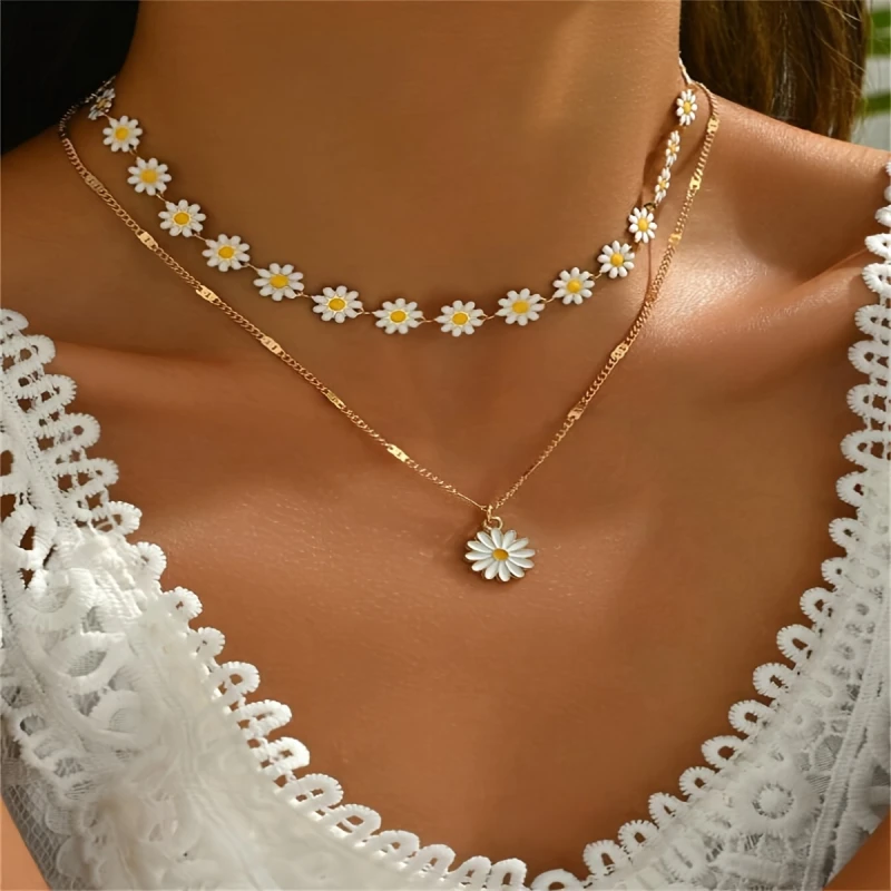Zestaw dwóch złotych naszyjników Daisy Bloom z biało-żółtymi stokrotkami – kwiatowy choker i dłuższy naszyjnik z zawieszką stokrotką (3).webp
