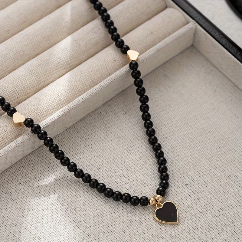 Czarny naszyjnik Black Heart z drobnymi koralikami, złotymi sercami i czarną zawieszką serce (1).webp